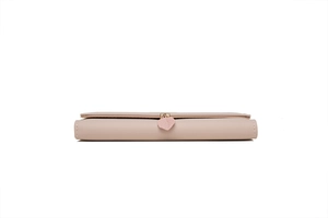Detail view of pink long wallet featuring a matte leather finish and leaf charm pendant