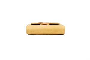 Detail view of ginger yellow tri-fold wallet showing side thickness and premium stitching