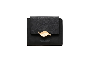 Detail of leaf buckle closure on minimalist black matte leather wallet for women