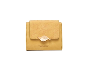 Detailed close-up of yellow bi-fold wallet with leaf print and metal leaf clasp closure