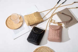 Vue à plat de petits sacs de téléphone matelassés en beige, noir et rose poudré