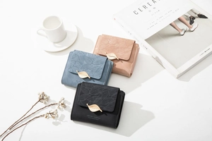 Detailed view of women short tri-fold wallets in black, blue and pink with leaf snap