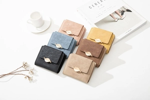 Close-up of short tri-fold wallets with leaf metal buckles and smooth PU leather texture