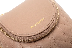 Détail du cuir matelassé beige avec fermeture éclair dorée et logo de marque