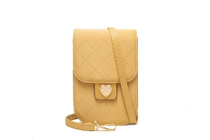 Detail der gesteppten Crossbody-Tasche in Ingwergelb mit goldenem Herzverschluss und Rautenmuster