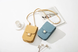 Detailansicht gesteppter PU-Handytaschen in Gelb und Blau mit goldenem Herzverschluss