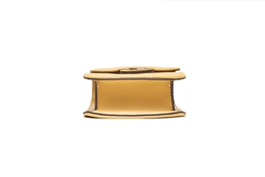 Makro-Detail der gelben PU-Leder-Stepptasche mit braunem Rand und goldenen Metallteilen