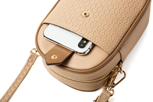 Détail d'un sac téléphone bandoulière beige avec texture tissée et finitions dorées