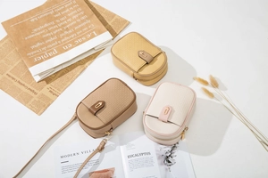 Vue détaillée de sacs de téléphone bandoulière tissés en jaune, marron et blanc crème