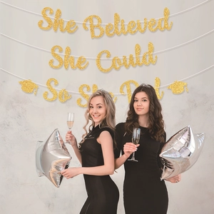 Glittering graduation banner She Believed She Could So She Did with bachelor cap decor