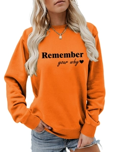 Dettaglio della stampa 'Remember your why' sulla felpa girocollo arancione da donna