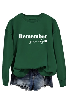 Dettaglio della felpa verde scuro con stampa di lettere bianche Remember your why
