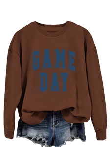 Close-up of Game Day 3D lettering on brown long sleeve crewneck sweatshirt flat lay