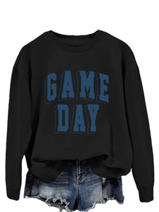 Detail of GAME DAY printed black sweatshirt paired with distressed denim shorts