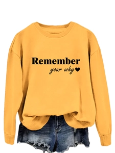 Dettaglio felpa gialla con stampa Remember Your Why e pantaloncini di jeans blu