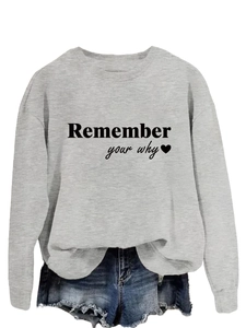 Dettaglio felpa grigio chiaro con stampa Remember Your Why e grafica a cuore