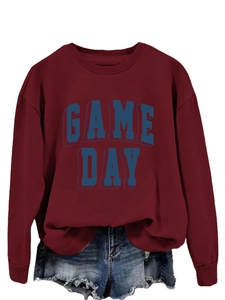 Detail of burgundy crewneck sweatshirt featuring blue 3D Game Day varsity lettering