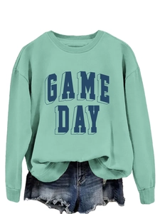 Detail of mint green crewneck sweatshirt with Game Day lettering and distressed denim shorts