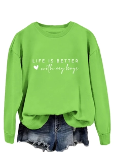 Détail du sweat vert avec texte Life is better with my boys et short en jean bleu