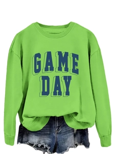 Close-up of bright green sweatshirt featuring blue 3D GAME DAY puff print text and fleece texture