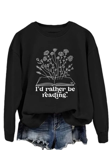 Detail of floral book graphic and text on a black long sleeve crewneck sweatshirt