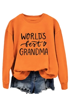 Flat lay of orange World's Best Grandma sweatshirt with frayed denim shorts