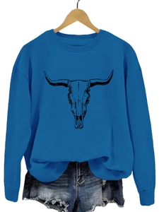Détail d'un sweat bleu avec motif de crâne de taureau et bords-côtes pour un look décontracté