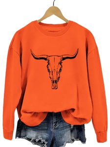 Détail du sweat orange à col rond avec imprimé crâne de taureau et bords-côtes