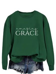 Close-up of Amazing Grace print on dark green crewneck sweatshirt and denim shorts