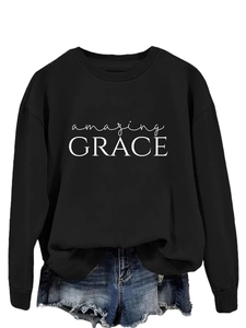 Detail of white Amazing Grace typography printed on black long-sleeved crewneck sweatshirt