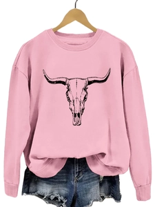 Détail d'un sweat rose à col rond avec imprimé tête de taureau noire sur cintre en bois