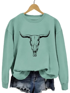 Détail d'un sweat vert sauge avec imprimé graphique de crâne de taureau longhorn noir