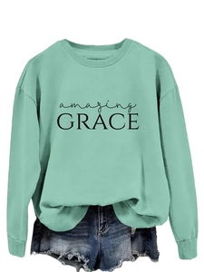 Close-up of mint green crew neck sweatshirt featuring bold black amazing GRACE print
