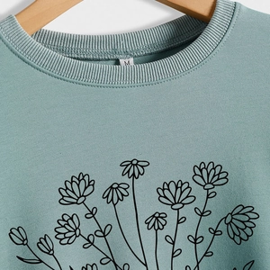 Sage green crewneck sweatshirt with minimalist black floral line art and ribbed neckline