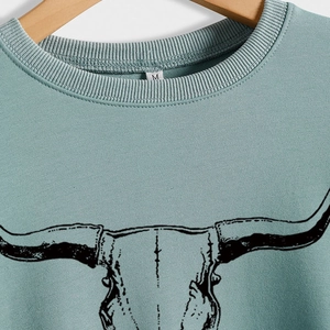 Sweat vert sauge à col rond avec imprimé tête de taureau vintage sur cintre en bois