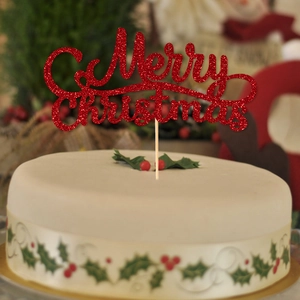 Sparkling red glitter Merry Christmas cake topper on a white festive winter holiday cake
