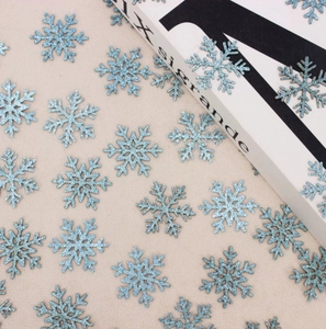 Close-up of light blue glitter snowflake confetti for Christmas party table decor