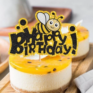 Glitter bee happy birthday cake topper on a cheesecake for first birthday party decor