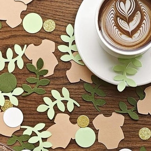 Baby birthday party confetti set with leafy shapes and golden glitter on a wood surface