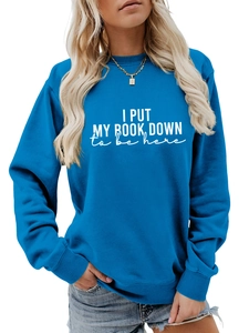 Detail of royal blue sweatshirt ribbing and I Put My Book Down white text print