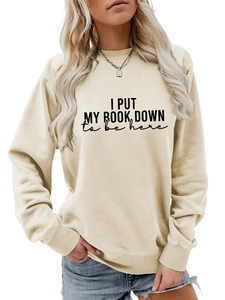Detail of ribbed cuffs and slogan print on cream long sleeve crewneck sweatshirt