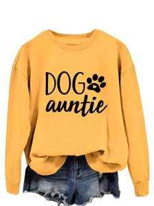 Détail du slogan Dog Auntie et de l'empreinte sur un sweat-shirt jaune à col rond