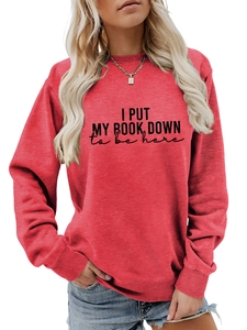 Detail of red crewneck sweatshirt with I Put My Book Down black letter print