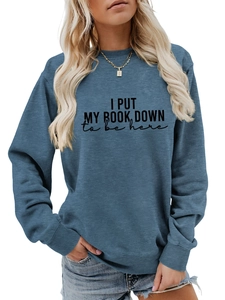 Detail of gray-blue sweatshirt featuring I PUT MY BOOK DOWN artistic text print