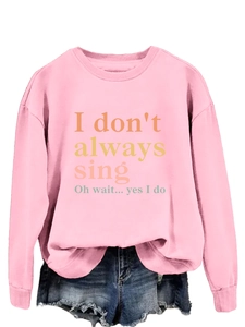 Detail of pink crewneck sweatshirt with 'I don't always sing' print and ribbed cuffs