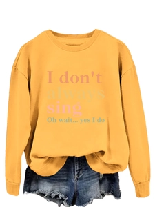Detail of ginger yellow long sleeve sweatshirt with colorful I don't always sing slogan