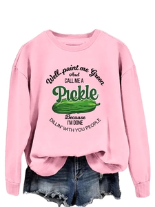 Detailed view of pink sweatshirt with pickle graphic paired with frayed denim shorts