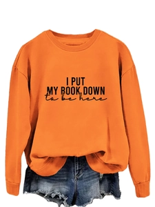 Detail of orange sweatshirt ribbed cuffs and 'I PUT MY BOOK DOWN' vintage lettering print