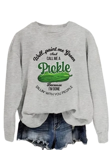 Detail of grey crewneck sweatshirt with pickle graphic and blue distressed denim shorts