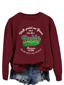 Detail of burgundy crewneck sweatshirt with green pickle illustration and graphic text